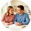 Pareja revisando un presupuesto de vivienda en una mesa luminosa